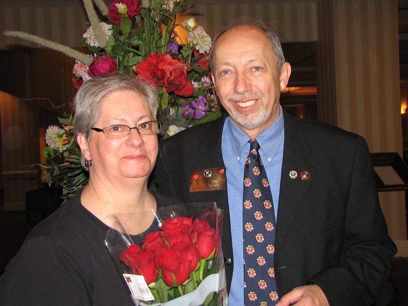 IMG_2651.JPG - Janet Hand gets a ‘hand’ and roses from Assistant Administrator Bill Hand for her administrative and computer support of the convention.  Thanks to all those many Kiwanians who are dedicated to the logistical support necessary to excel!