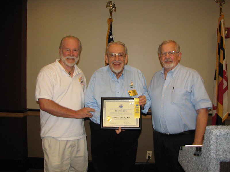 IMG_5383.JPG - PG John Tyner of the Rockville Club (L) and Past President of the Capital District Kiwanis Foundation and Olney Club member Stan Miller congratulate PLG and Bethesda Club President Jim Leder for his Division Leadership of the Kiwanis Miracle League Baseball League project in Maryland.  Jim drew in all clubs in the division plus many Key Clubs to support the new Miracle League field Grand Opening last August.  John and Stan presented Jim with his second Capital District Kiwanis Foundation Life Member ‘Unsung Hero’ Award for his tremendous creativity, tenacity and success in getting this opened after five years of leadership.  Jim has earned his “life Member with Oak Leaf Cluster”.  Thank you, Jim, from everyone !Jim is the president of the Miracle League of Montgomery County Maryland, Inc. and is its founder and leading promoter.  He and his team have taken the idea from the 2006 KI Convention in Montreal to reality with five years hard work and creativity by working in partnership with Montgomery County Park & Planning Department and the Lerner Foundation/Washington National professional baseball team.  All these three organizations … Kiwanis – Washington Nationals Baseball Team Organization – The Park & Planning Department … in partnership brought the Miracle League into existence.  This is a very special ball field designed for physically/mentally challenged children and adults to play safely on a rubberized field.  The Kiwanis Foundation of Bethesda, Maryland, provided very significant seed money to start the project.  The one of a kind field in Maryland is located at the Montgomery County Soccer Plex in Germantown.  It is really spectacular !