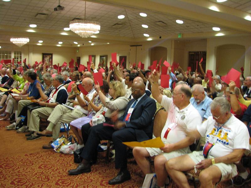 IMG_4469.JPG - Voting in the two Delegate Sessions on amendments and then candidates for District Governor and Governor Elect were done by holding up a red card to help with tabulation.  Each club should have three delegates at a District convention. There were 250 delegates and delegates at large present from the 173 Kiwanis Clubs of the District.